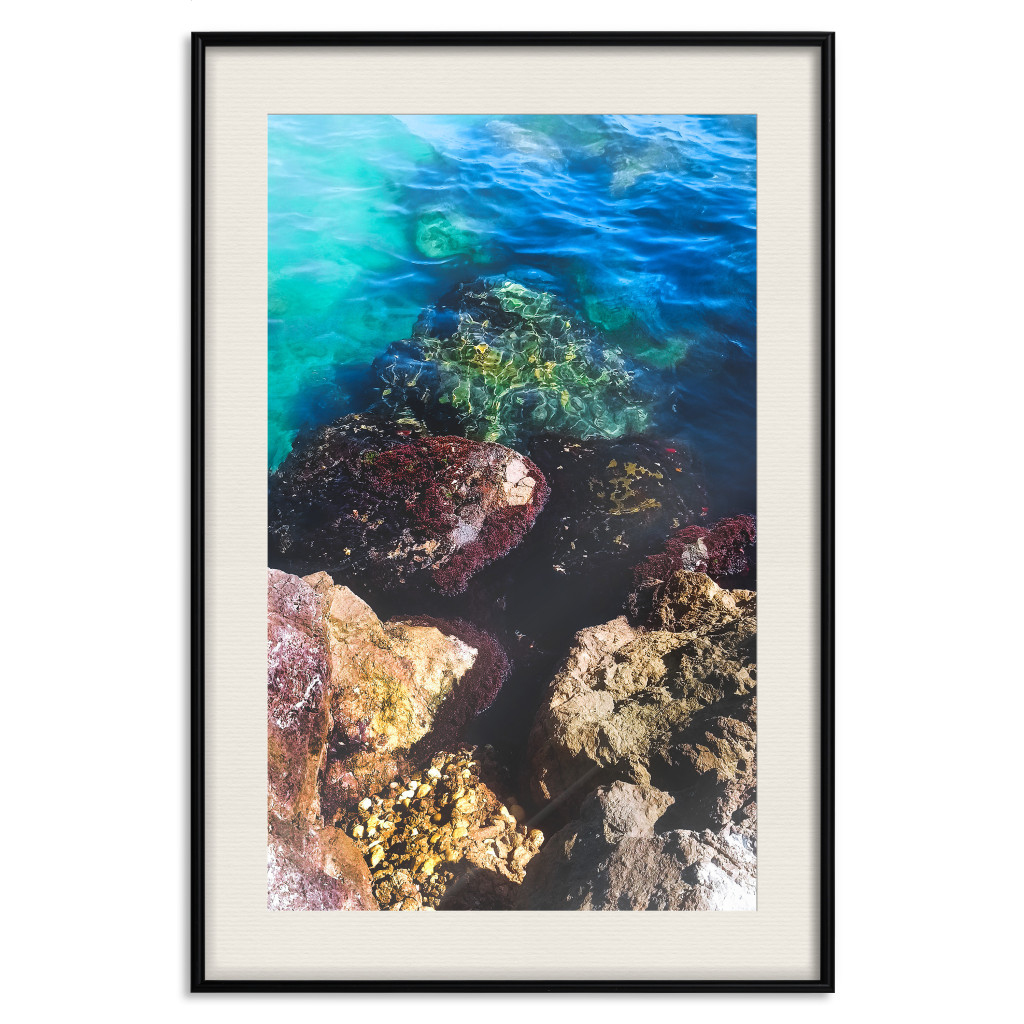 Muur Posters Rocky Shore Of The Sea - Photo Of Colored Stones And Blue Water